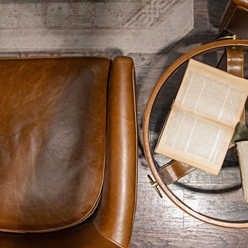 leather chairs and table top with books and a tea cup on saucer