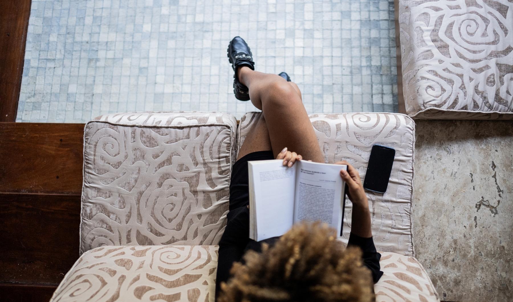 woman reads a book on a chair